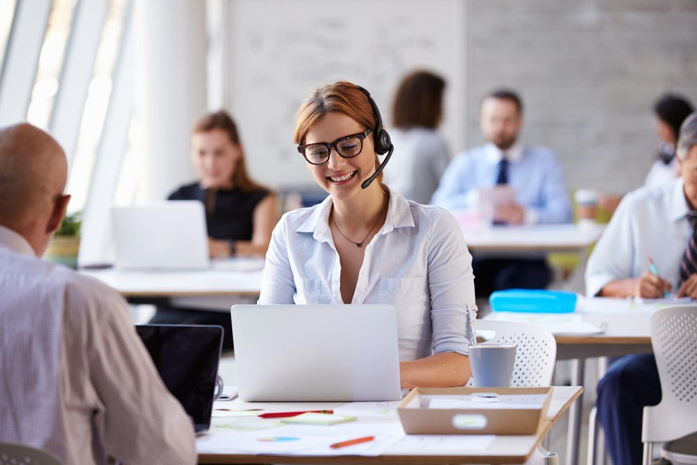 Businesswoman Using Laptop In Customer Service Department