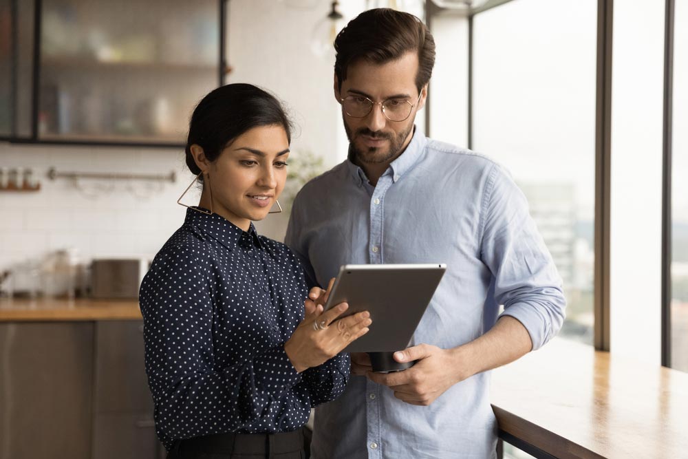 Close up diverse colleagues using tablet together