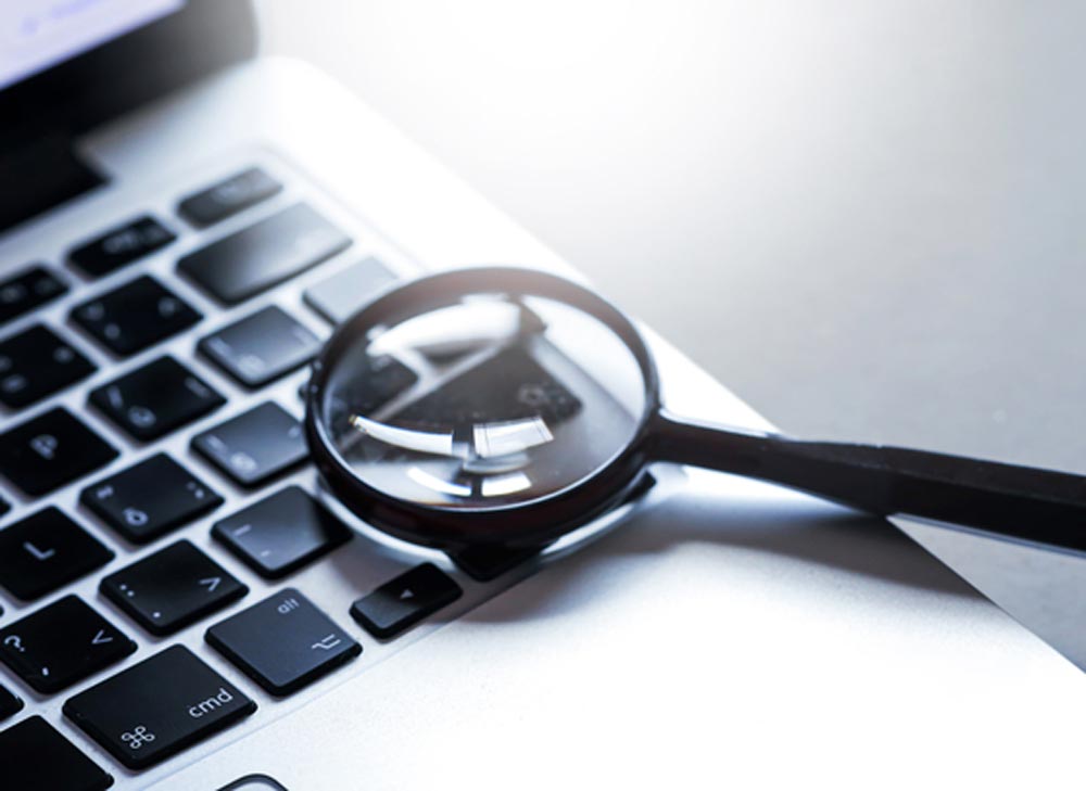 Magnifying glass put on close up of Laptop computer. Internet search concept