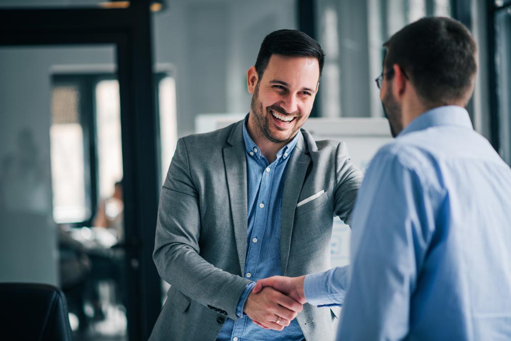 Portrait of cheerful young manager handshake with new employee