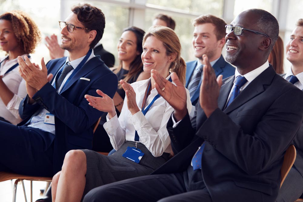 Smiling audience applauding at a business seminar